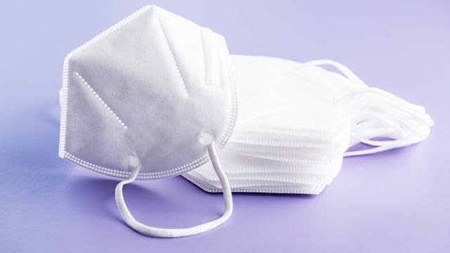 KN95 face mask. FFP2 mask as covid-19 protection. Coronavirus mask on violet table.