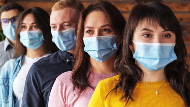 Crowd of young people wearing masks on their faces during the coronavirus pandemic - New normal masked millennials - New concept of normal life