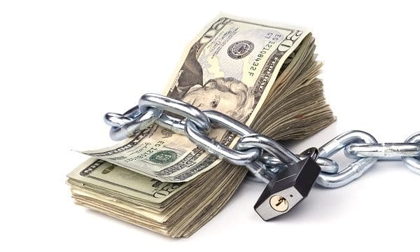 A stack of currency chained together and padlocked.  Used for any money inference where money is tight or protected.