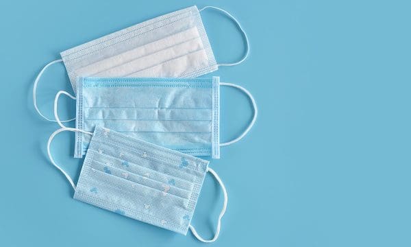 Medical masks on blue background. Typical 3-ply surgical mask to cover the mouth and nose. Procedure mask from bacteria. Healthcare and protection concept.