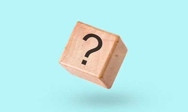Wooden block on a turquoise background with a question mark - Cube with a question mark symbol in zero gravity and levitation - Concept of brainstorming and problem solving