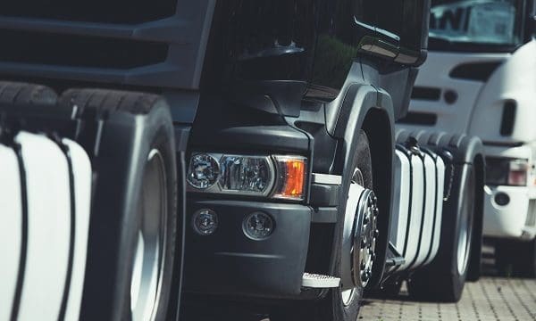 Heavy Transportation Convoy. Semi Trucks on the Road Closeup Photo