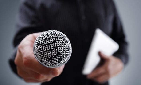 Hand holding a microphone conducting a business interview or press conference
