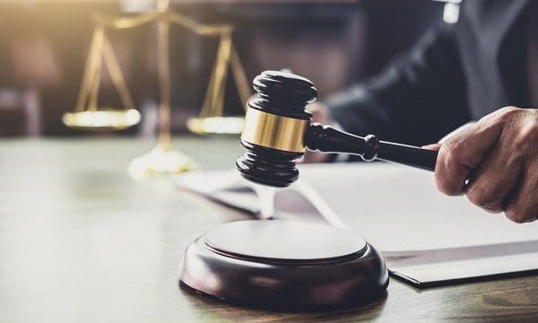Judge gavel with Justice lawyers, Gavel on wooden table and Counselor or Male lawyer working on a documents. Legal law, advice and justice concept.
