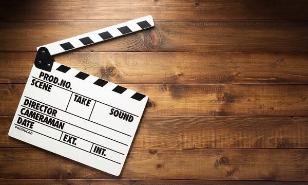 movie clapper board at wooden background texture, top view