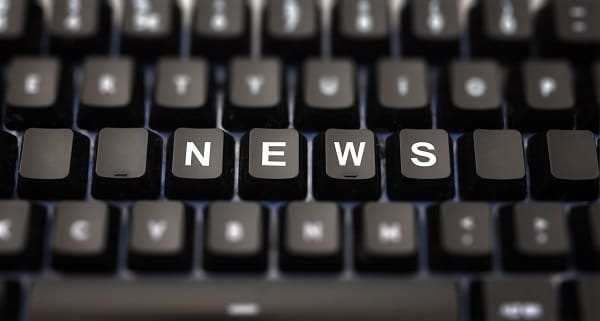 Online news, journalism concept. News word written on keypad. Black keys with white letters message for press articles on pc keyboard. Blur buttons background.