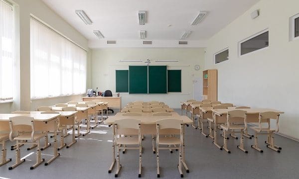 empty school class before final exams. desks and chairs are neatly arranged in three rows. overall plan