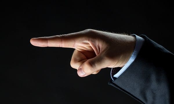 business, people and choice concept - close up of businessman hand pointing finger to something invisible over black background