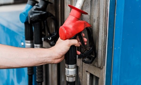 selective focus of man holding red gas pump on gas station