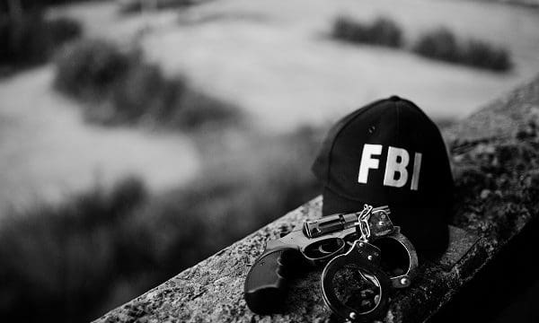 FBI cap with revolver and handcuff.
