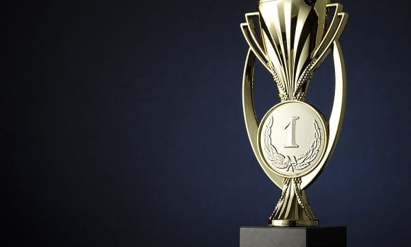 Gold cup or trophy with an engraved medallion with number 1 and laurel wreath for the winner of a championship or competition