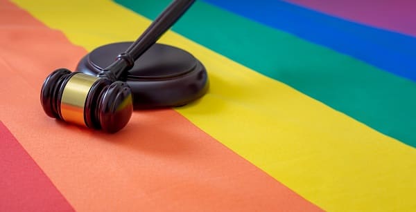 LGBT Law, Gay marriage. Judge gavel on rainbow color flag, close up view. Transgender rights, Copy space