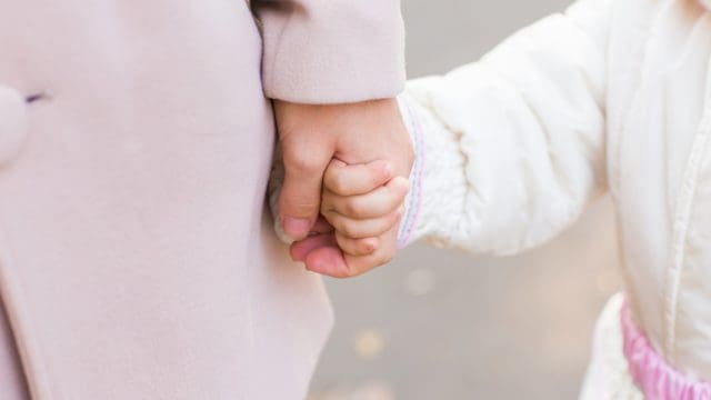 Child holding mother's hand. Mother's love in the hand, on the palm