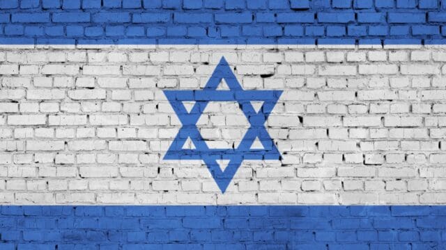Israel flag is painted onto an old brick wall