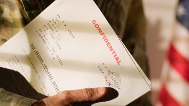 American military office with military man holding documents.