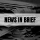 Text that says News In Brief on a white rectangle with newspapers in the background