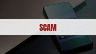 Red text that says Scam on a white rectangle with a smartphone in the background
