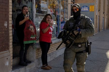 Bystanders film a federal agent in the Little Village neighborhood during a deportation drive, Chicago last year. (SRN NEWS/REUTERS photo)
