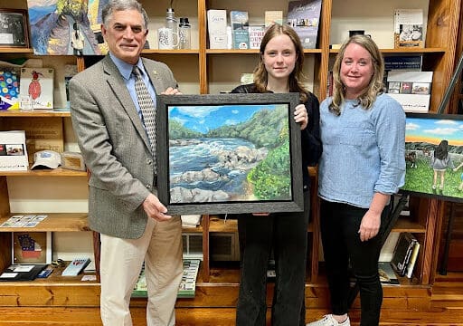Rep. Clyde awards Second Place to Calli Carlisle’s (center) “Chattahoochee River: Horseshoe.” (Photo courtesy Andrew Clyde)
